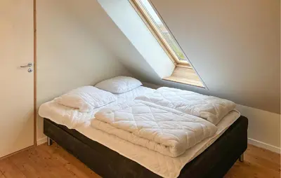 an unmade bed in a room with a window at 4 Bedroom Beach Front Home In Vinderup in Vinderup
