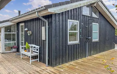 a black house with a porch and a wooden deck at Lovely Home In Fjerritslev With Wifi in Fjerritslev