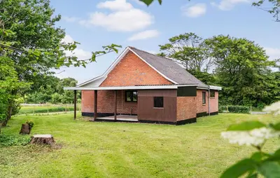a small brick building in a field with a yard at 1 Bedroom Nice Home In Hurup Thy in Ullerup