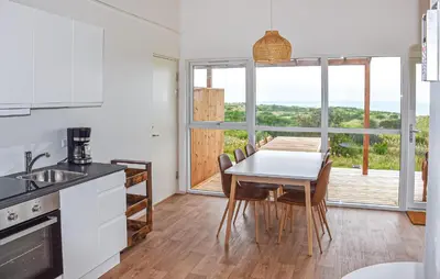 a kitchen and dining room with a table and chairs at Gorgeous Home In Hanstholm With House Sea View in Hanstholm