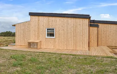a wooden house with a deck and a window at Nice Home In Hanstholm With House Sea View in Hanstholm