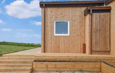 a small wooden building with a window and stairs at Nice Home In Hanstholm With House Sea View in Hanstholm
