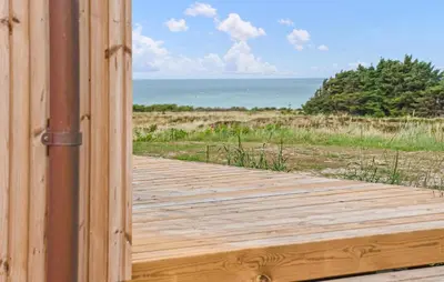 a wooden door leading to a beach with the ocean at 5 Bedroom Amazing Home In Hanstholm in Hanstholm