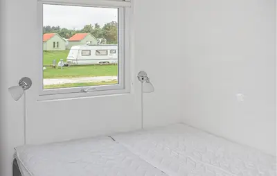 a white bedroom with a bed and a window at 5 Bedroom Amazing Home In Hanstholm in Hanstholm