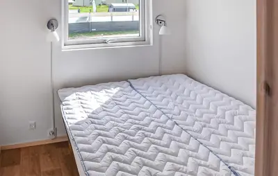 a bed in a room with a window at 5 Bedroom Amazing Home In Hanstholm in Hanstholm