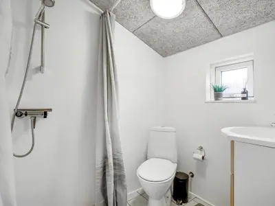 a bathroom with a toilet and a sink at Holiday Home Sylvana - 75m from the sea by Interhome in Thisted