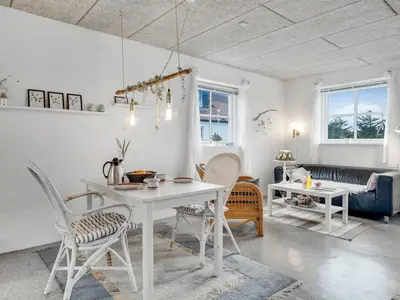 a living room with a white table and chairs at Holiday Home Sylvana - 75m from the sea by Interhome in Thisted