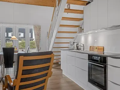 a kitchen with white cabinets and a stairway at Apartment Benthe - 100m to the fjord by Interhome in Vestervig