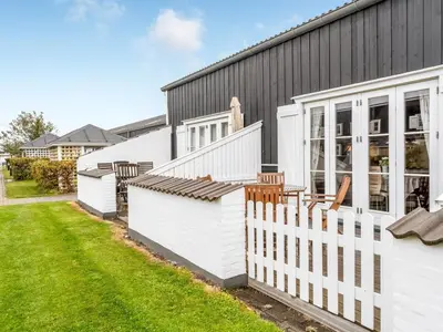 a black house with a white fence next to a yard at Apartment Benthe - 100m to the fjord by Interhome in Vestervig