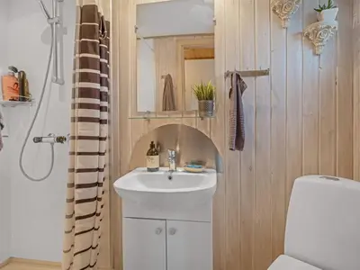 a bathroom with a sink and a toilet and a mirror at Apartment Benthe - 100m to the fjord by Interhome in Vestervig