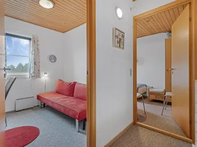 a living room with a red couch and a mirror at Apartment Benthe - 100m to the fjord by Interhome in Vestervig