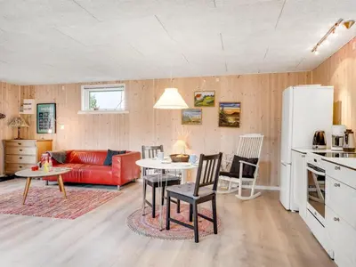 a kitchen and living room with a red couch at Holiday Home Tekla - 75m from the sea by Interhome in Thisted