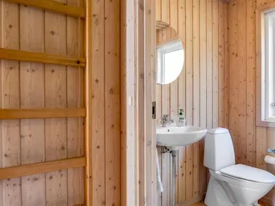 a bathroom with a toilet and a sink at Holiday Home Melita - 2km from the sea by Interhome in Blokhus