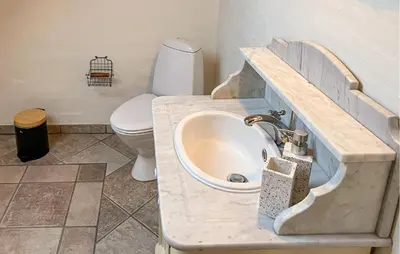 a bathroom with a sink and a toilet at 5 Bedroom Awesome Home In Lemvig in Lemvig