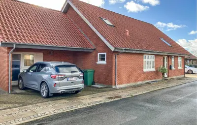 a car parked in front of a brick house at 5 Bedroom Awesome Home In Lemvig in Lemvig