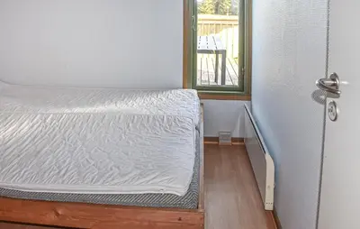 a bed in a room with a door and a window at Gorgeous Home In Hanstholm With Swimming Pool in Hanstholm