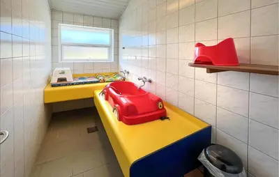 a small bathroom with a red bag on a yellow counter at Gorgeous Home In Hanstholm With Swimming Pool in Hanstholm