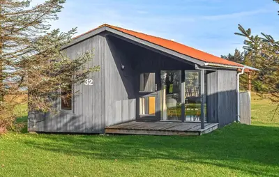 a small gray shed with an orange roof on a field at Gorgeous Home In Hanstholm With Swimming Pool in Hanstholm