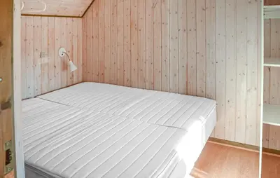 a white bed in a room with wooden walls at Gorgeous Home In Hanstholm With Outdoor Swimming Pool in Hanstholm
