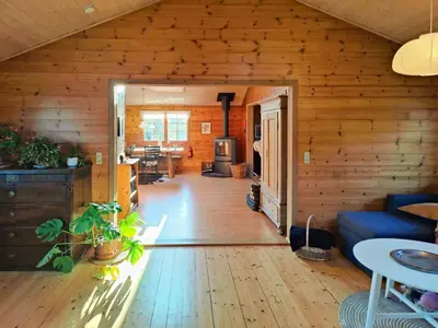 a living room with wooden walls and a wooden floor at Cozy Cottage Close To Thy National Park in Thisted