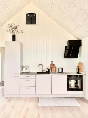 a kitchen with white cabinets and a sink at Summer House Surrounded By Reeds Near Limfjorden in Lemvig