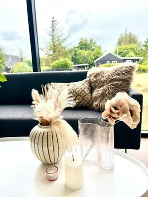 a table with a candle and a couch at Summer House Surrounded By Reeds Near Limfjorden in Lemvig