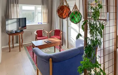 a living room with a blue couch and a tv at 2 Bedroom Stunning Home In Lemvig in Lemvig