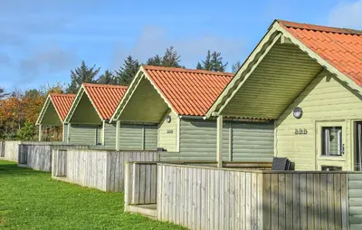 a row of houses with red roofs behind a fence at 2 Bedroom Stunning Home In Hanstholm in Hanstholm