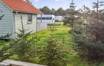 a yard with a house and trees and a trailer at 1 Bedroom Cozy Home In Hanstholm in Hanstholm