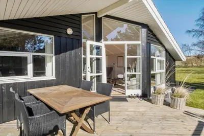 a house with a wooden table and chairs on a deck at JB368-Fjerritslev-Ahornvej-38
