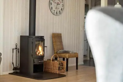 a fireplace in a living room with a clock on the wall at JB368-Fjerritslev-Ahornvej-38