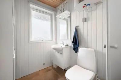 a white bathroom with a toilet and a sink at LK2201-Lokken-Kristavej-45 in Grønhøj