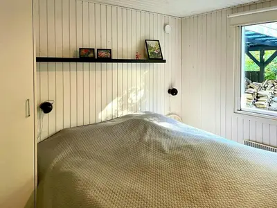 a bedroom with a bed in a room with a window at Nature Retreat With Fjord Views Near Spøttrup in Spottrup
