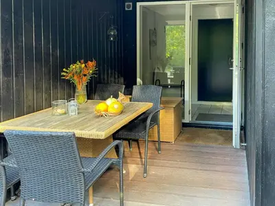 a wooden table with a bowl of fruit on a patio at Nature Retreat With Fjord Views Near Spøttrup in Spottrup
