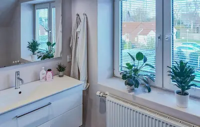 a bathroom with a sink and a window with plants at Nice Home In Thyholm With Wifi in Thyholm