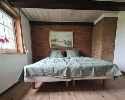 a bed in a room with a brick wall at Horse Estate Farm Stay - Beautiful Surroundings in Bøvlingbjerg