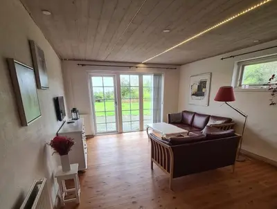 a living room with a couch and a table at Horse Estate Farm Stay - Beautiful Surroundings in Bøvlingbjerg