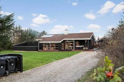 a house with a gravel driveway in front of it at BL1144-Blokhus-Sixtusvej-27 in Blokhus