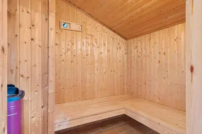 a wooden sauna with a trash can in the corner at BL1144-Blokhus-Sixtusvej-27 in Blokhus