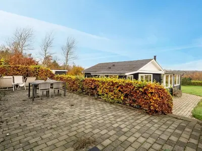 a house with a table and chairs on a patio at Holiday Home Hjalma - 250m to the fjord by Interhome in Farsø