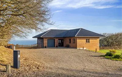 a brick house with a garage on a gravel driveway at Gorgeous Home In Lemvig With Wifi in Lemvig