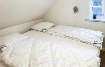 two white pillows sitting on a bed in a room at 6 Bedroom Awesome Home In Hurup Thy in Tvolm