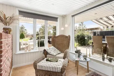 a screened in porch with a chair and a table at JB301-Fjerritslev-Landstien-3 in Fjerritslev