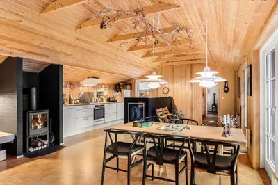 a kitchen and dining room with a table and a fireplace at JB238-Brovst-Baunehojvej-37 in Brovst