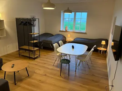 a living room with a table and a couch at Kildebakkegaard Bed and Breakfast in Nørager