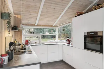 a kitchen with white cabinets and a large window at BL1141-Saltum-Faarup-Klitvej-2-A in Saltum