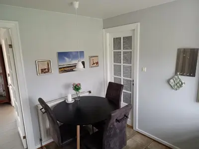 a dining room with a black table and chairs at Bolig ved hav og fjord in Thyholm