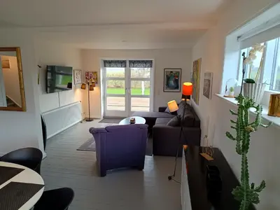 a living room with a couch and a table at Bolig ved hav og fjord in Thyholm