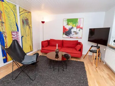 a living room with a red couch and a table at 4 person holiday home in Hanstholm in Hanstholm