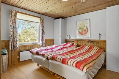 a bedroom with a large bed and a window at JB404-Fjerritslev-Jesper-Jensensvej-9 in Slettestrand